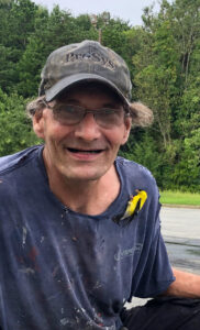 Everkem production manager Bobby, smiling with a goldfinch on his shirt.